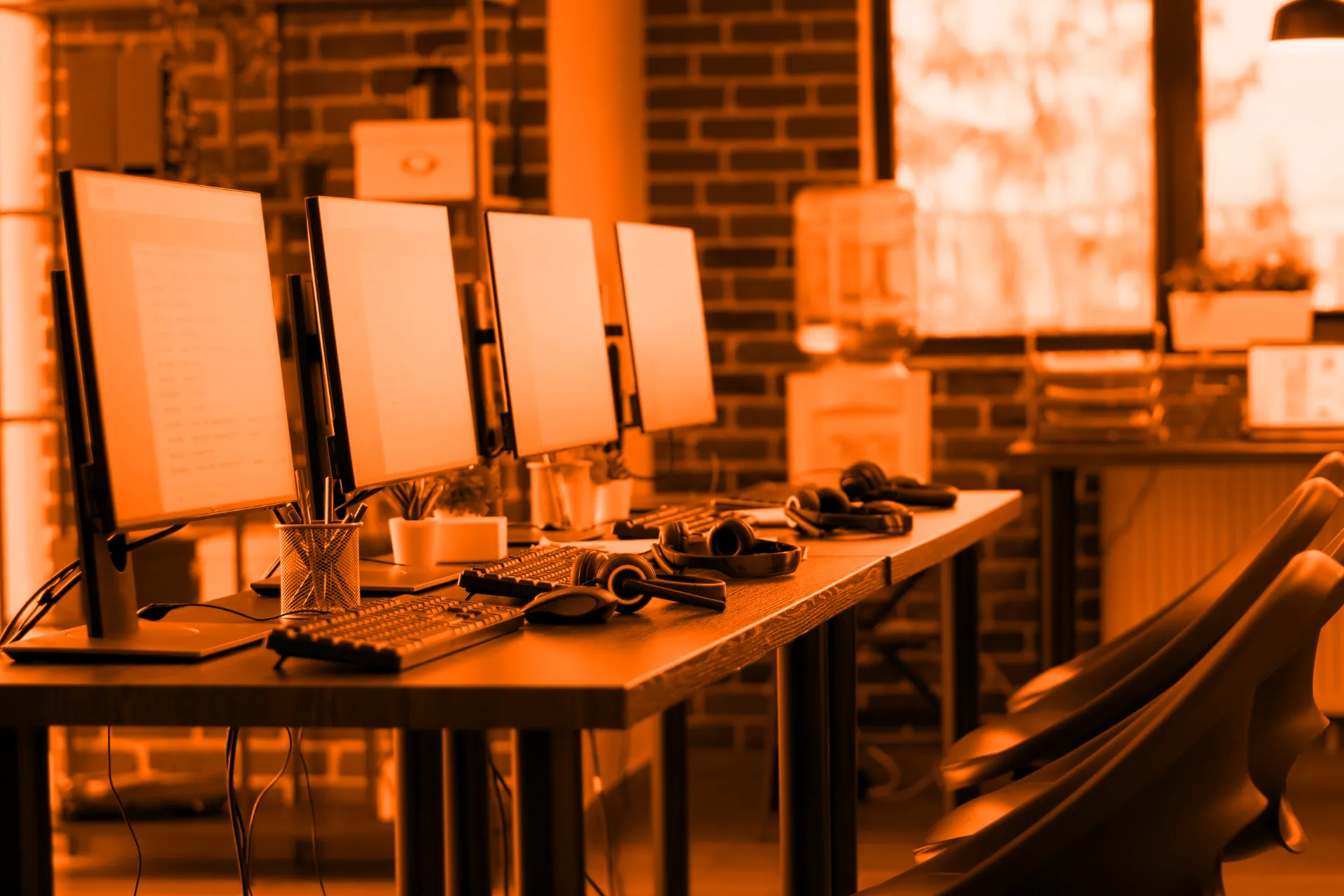 Modern office with row of PCs and headsets